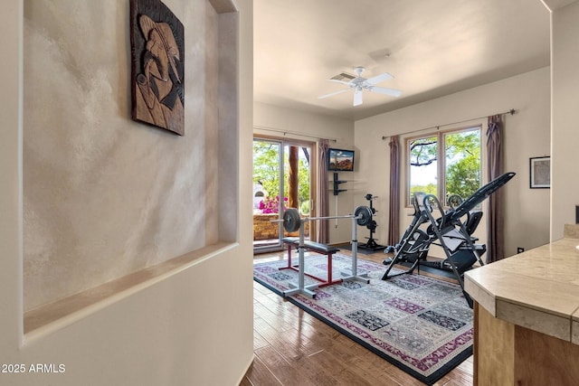 workout room featuring visible vents, wood finished floors, and a ceiling fan