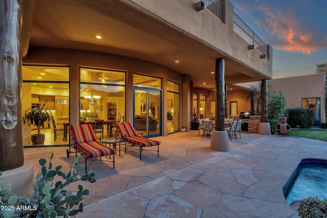 view of patio with an outdoor pool and a balcony