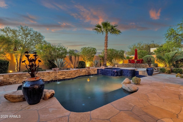 pool at dusk with a patio, a fenced backyard, and an outdoor pool