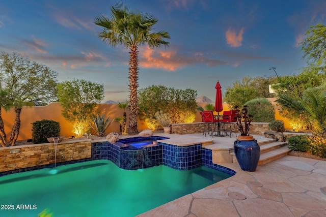 view of pool featuring a patio, a fenced in pool, a fenced backyard, and an in ground hot tub