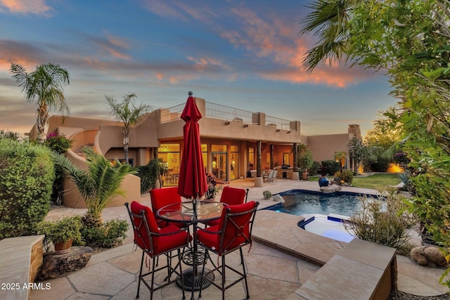 pool featuring outdoor dining space, a patio area, and an in ground hot tub