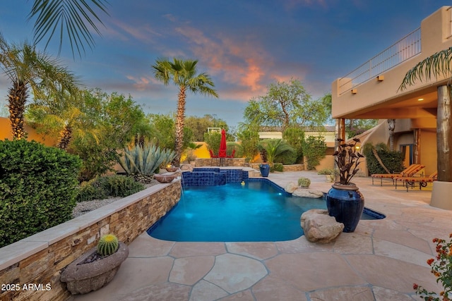 pool at dusk with a patio, an outdoor pool, a fenced backyard, and a hot tub