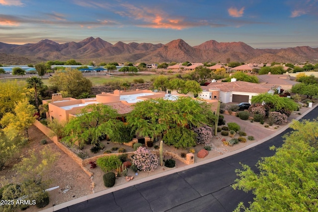 aerial view at dusk featuring a mountain view