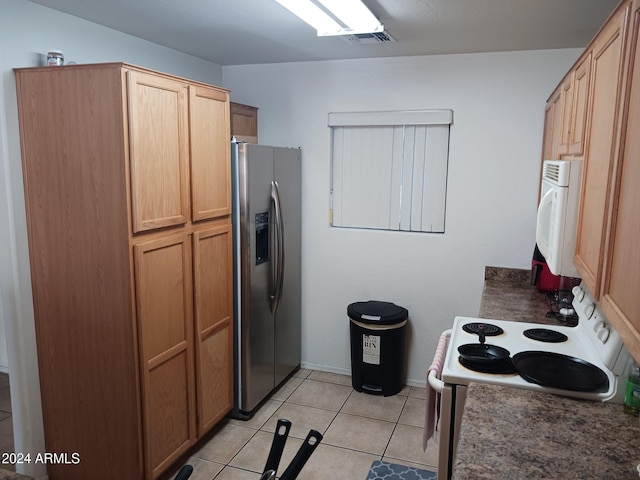 7118 S 37th Gln, Phoenix, AZ 85041 - kitchen with stainless steel fridge with ice dispenser, white range with electric cooktop, dark countertops, light tile patterned floors, and baseboards