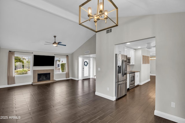 5435 E Cambridge Ave, Phoenix, AZ 85008 - unfurnished living room with a ceiling fan, dark wood-type flooring, a fireplace with raised hearth, high vaulted ceiling, and a chandelier