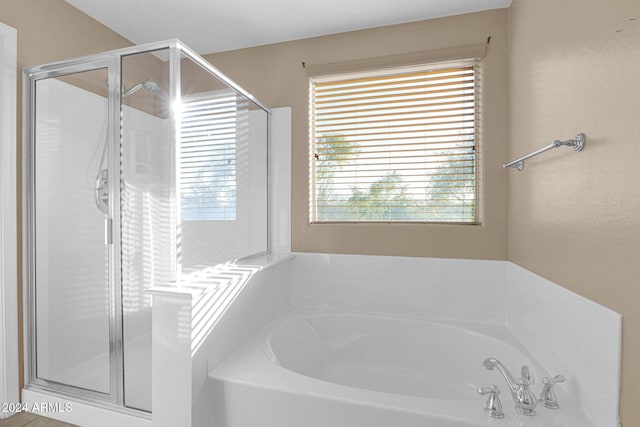 bathroom featuring shower with separate bathtub