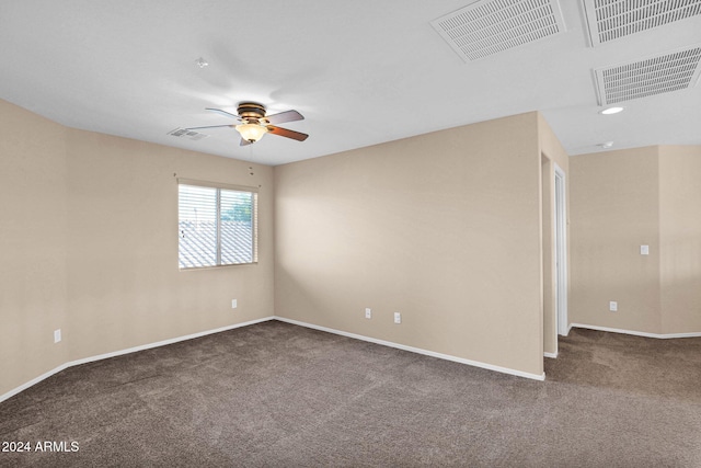 empty room with dark colored carpet and ceiling fan