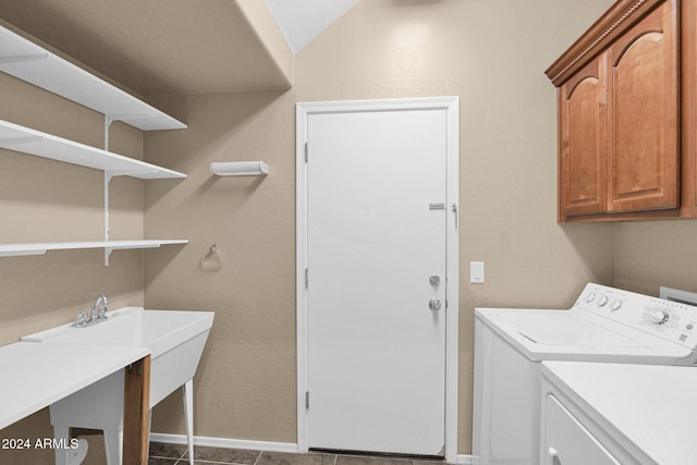 laundry room featuring cabinets, separate washer and dryer, and dark tile patterned flooring