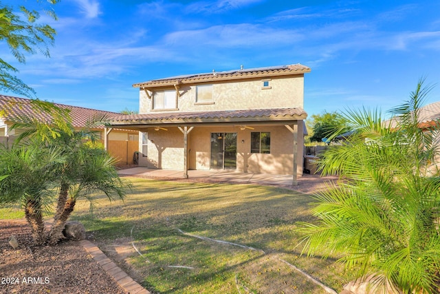 back of house featuring a patio and a lawn