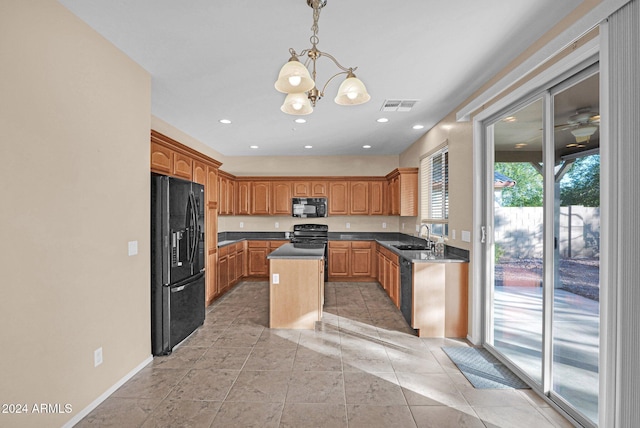 kitchen featuring sink, a center island, an inviting chandelier, pendant lighting, and black appliances