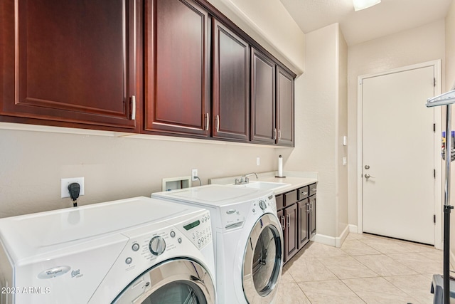 clothes washing area with cabinets, light tile patterned flooring, sink, and washer and clothes dryer