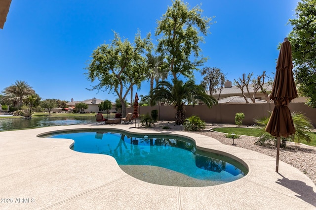 view of swimming pool with a patio area and a water view