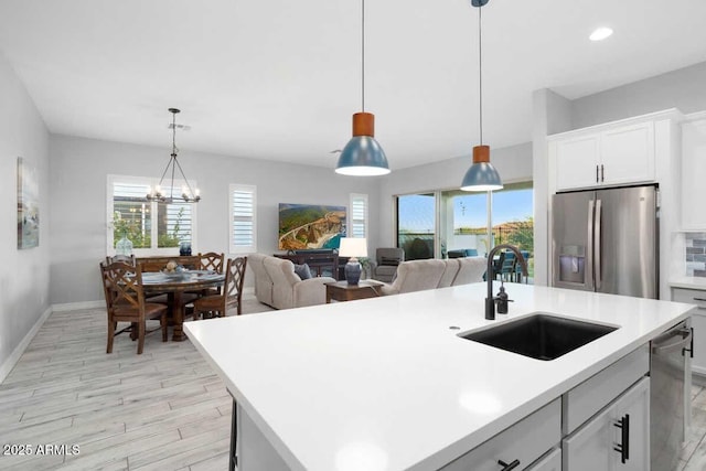 kitchen featuring light countertops, appliances with stainless steel finishes, a sink, and a wealth of natural light