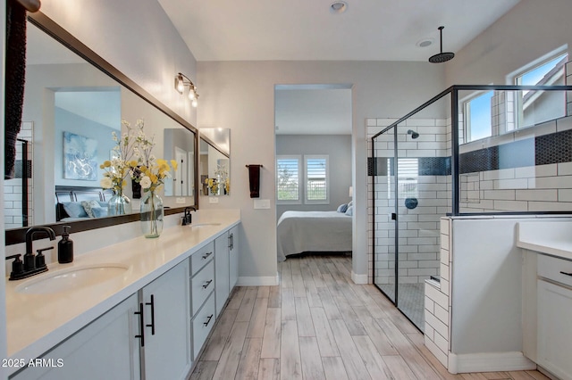 ensuite bathroom with connected bathroom, a tile shower, and a sink