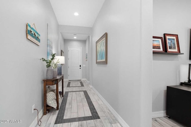 hall with recessed lighting, light wood-style flooring, and baseboards