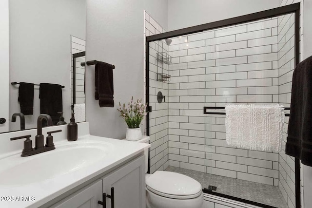 full bathroom featuring a stall shower, vanity, and toilet