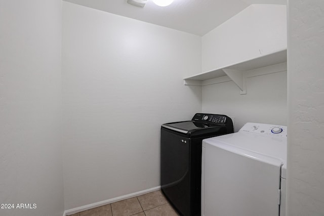 laundry area with washer and clothes dryer and light tile patterned floors