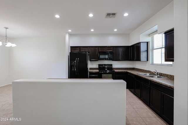 kitchen with pendant lighting, sink, a center island, and black appliances