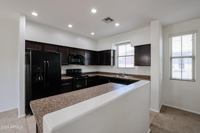 kitchen featuring a wealth of natural light, sink, a center island, and black appliances