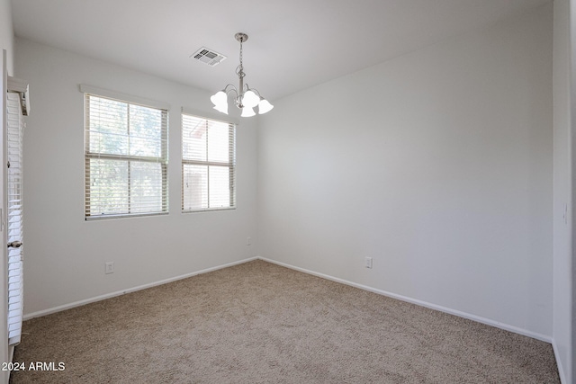 unfurnished room with carpet floors and an inviting chandelier