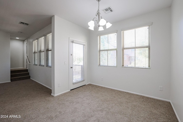 unfurnished room featuring carpet floors and a notable chandelier