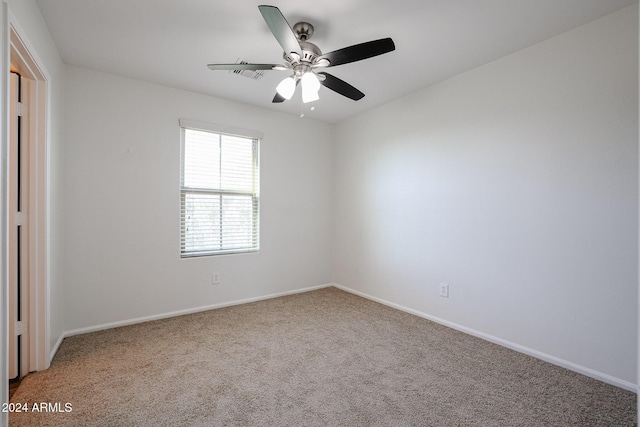 carpeted spare room featuring ceiling fan