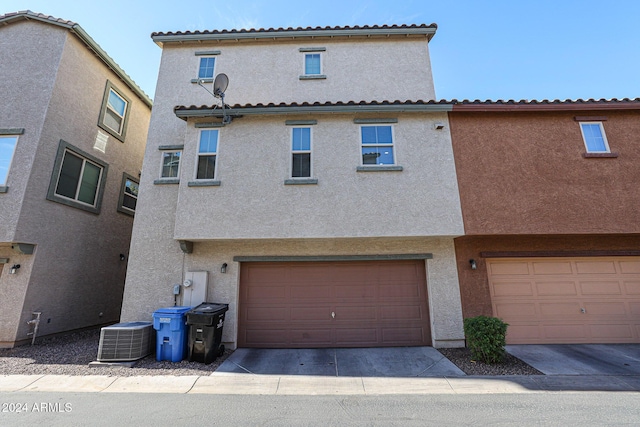 back of property with a garage and cooling unit