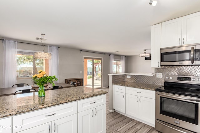 kitchen with visible vents, light wood-style flooring, tasteful backsplash, white cabinetry, and stainless steel appliances