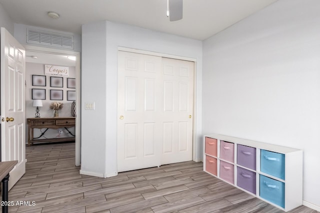 unfurnished bedroom featuring visible vents, a ceiling fan, a closet, and wood tiled floor
