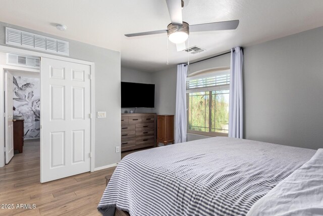 bedroom featuring light wood-type flooring, visible vents, baseboards, and a ceiling fan