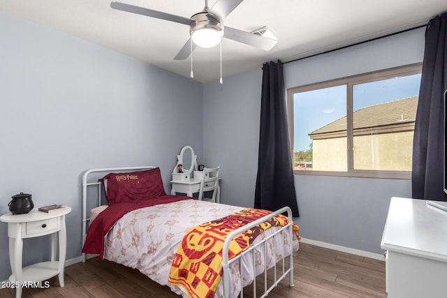 bedroom featuring visible vents, baseboards, wood finished floors, and a ceiling fan