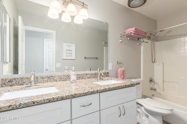 bathroom with a sink, bathing tub / shower combination, toilet, and double vanity