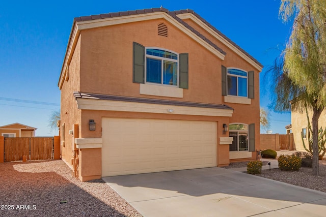 view of front of property featuring stucco siding, an attached garage, concrete driveway, and fence