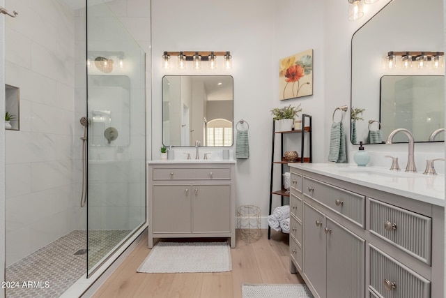 bathroom featuring vanity, wood-type flooring, and tiled shower