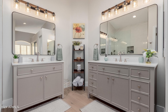 bathroom with a shower, wood-type flooring, and vanity