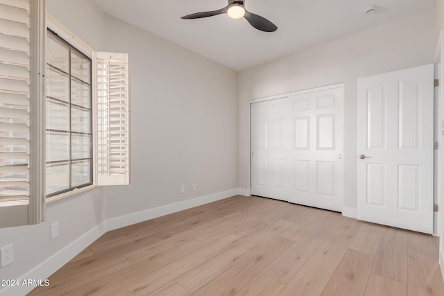 unfurnished bedroom with ceiling fan, a closet, and light wood-type flooring