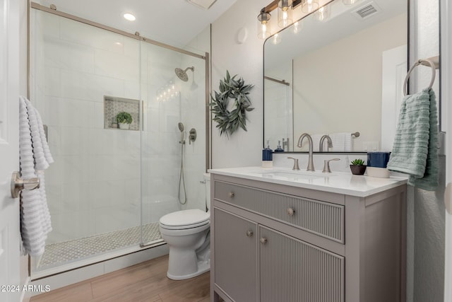 bathroom featuring hardwood / wood-style flooring, vanity, toilet, and an enclosed shower