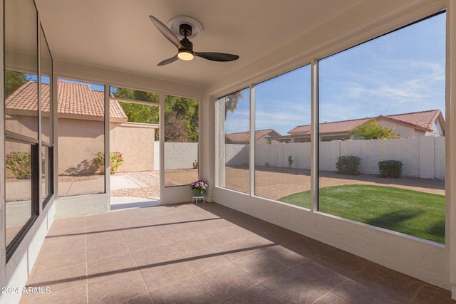 unfurnished sunroom with ceiling fan