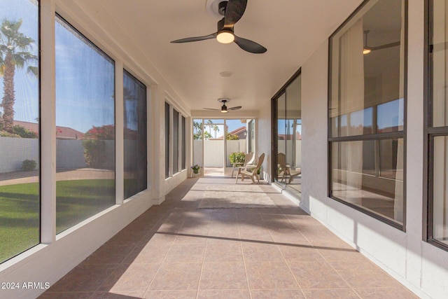 unfurnished sunroom featuring ceiling fan