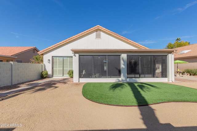 rear view of property featuring a patio area and a sunroom