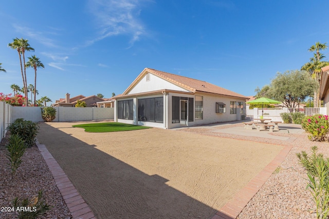 back of house featuring a sunroom and a patio