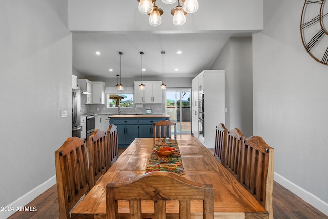 dining space with a notable chandelier, sink, and hardwood / wood-style flooring