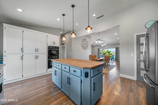 kitchen featuring pendant lighting, white cabinets, a kitchen island, and stainless steel refrigerator