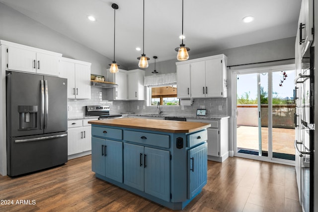 kitchen featuring pendant lighting, wood counters, white cabinets, a kitchen island, and stainless steel appliances