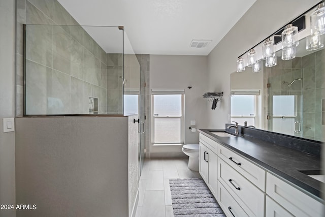 bathroom with vanity, tile patterned flooring, an enclosed shower, and toilet