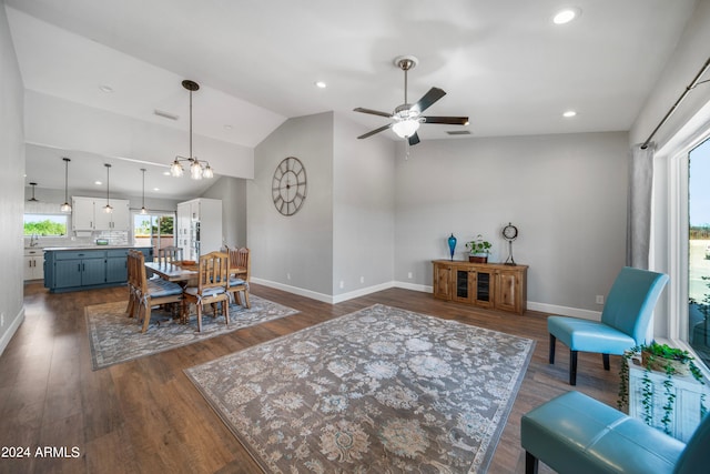 dining room featuring ceiling fan with notable chandelier, lofted ceiling, and dark hardwood / wood-style floors