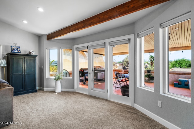 doorway featuring light carpet and beamed ceiling