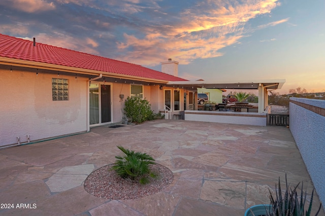 patio terrace at dusk featuring exterior kitchen