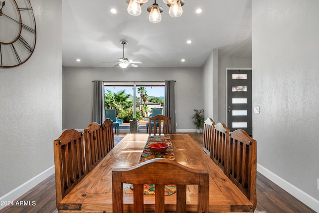 dining area featuring ceiling fan with notable chandelier and dark hardwood / wood-style flooring