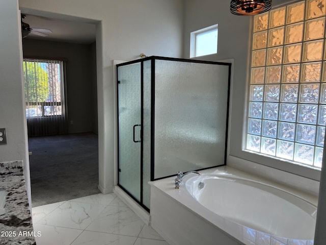 bathroom featuring ceiling fan and separate shower and tub